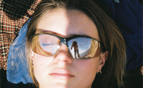 Woman in sunnies lying on beach